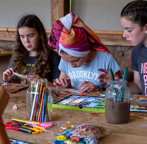 Three girls creating with craft supplies