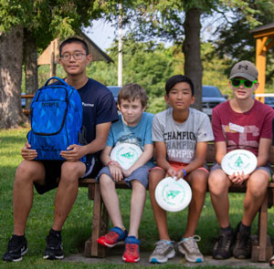 kids sitting holding discs preparing for disc golf class